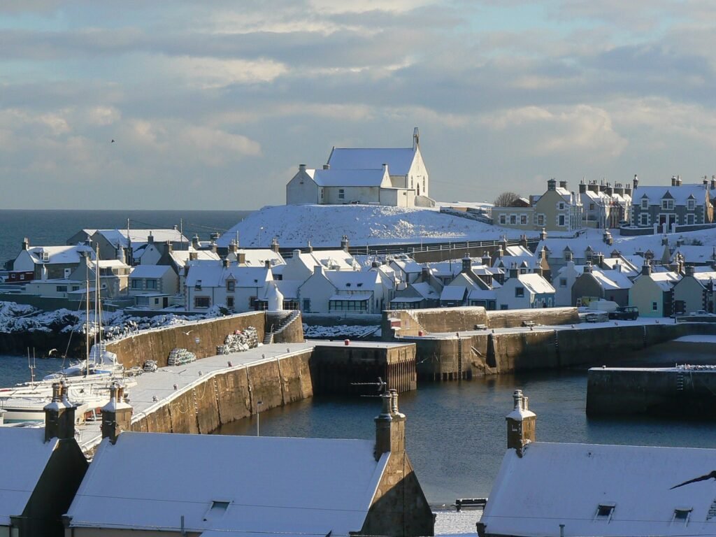 Snow-covered rooftops and harbour in winter.